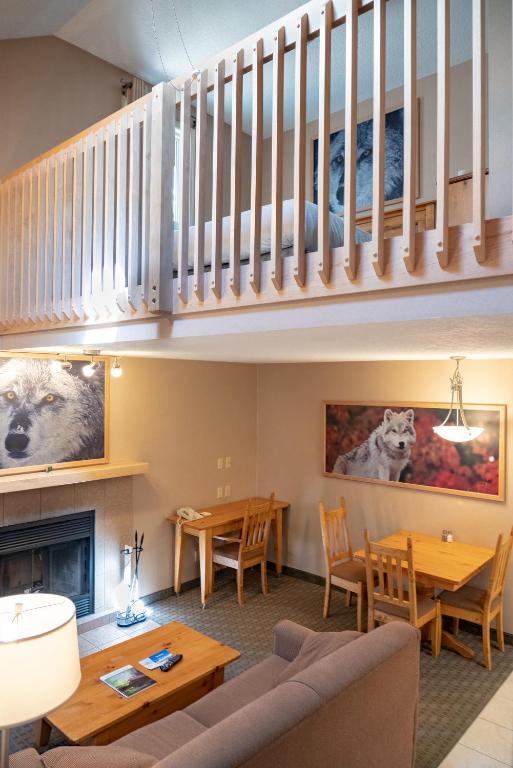 a living room with a couch and tables and a staircase at Banff Rocky Mountain Resort in Banff