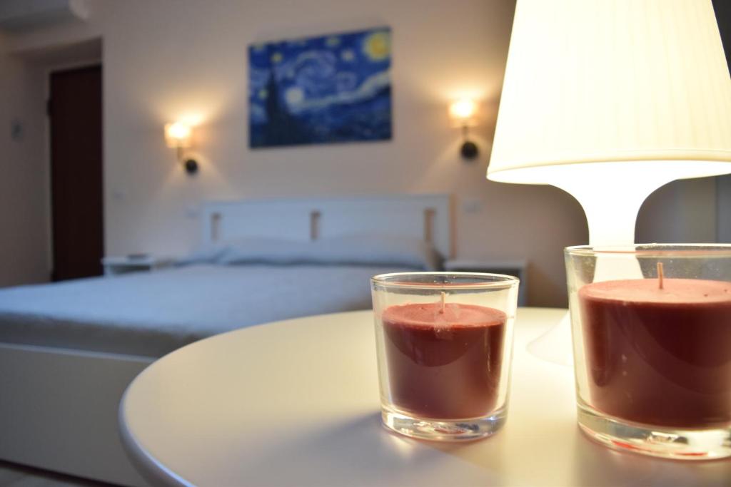 une table avec une lampe et deux verres dessus dans l'établissement Altomuro 39 di S.A., à Formia