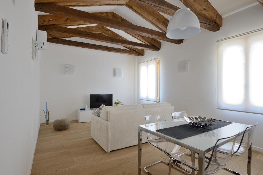 uma sala de estar branca com uma mesa e um sofá em Ve-nice Suite Casa Teresa C881 em Veneza