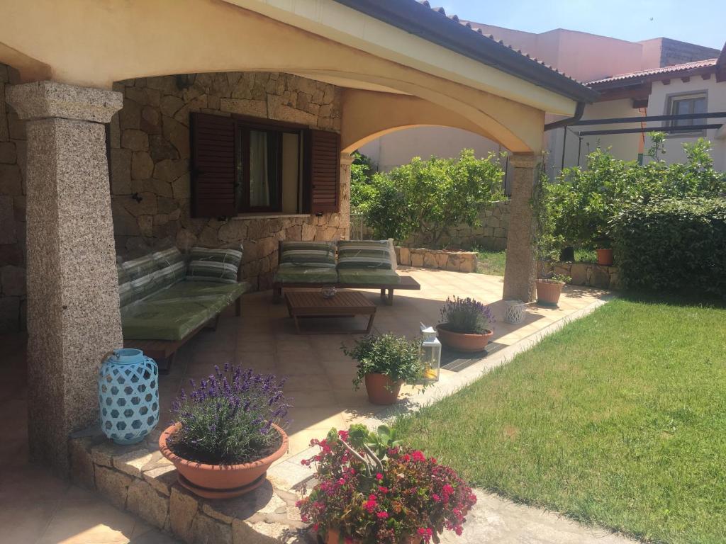 ブドーニにあるSa Murta Bianca Guesthouseの庭のベンチや鉢植えの植物があるパティオ