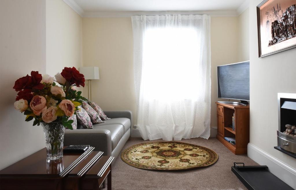 Dale Street Apartments Suite في ليمينغتون سبا: غرفة معيشة مع أريكة ونافذة