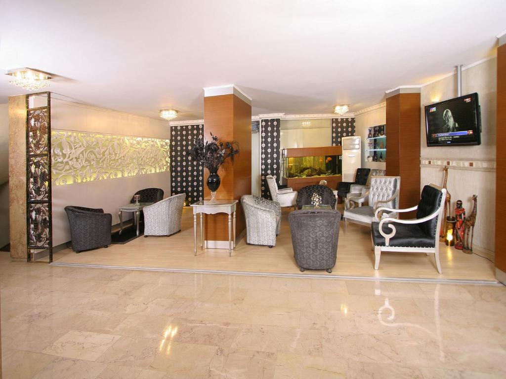 vestíbulo con sala de espera con sillas y TV en Maya Hotel, en Estambul