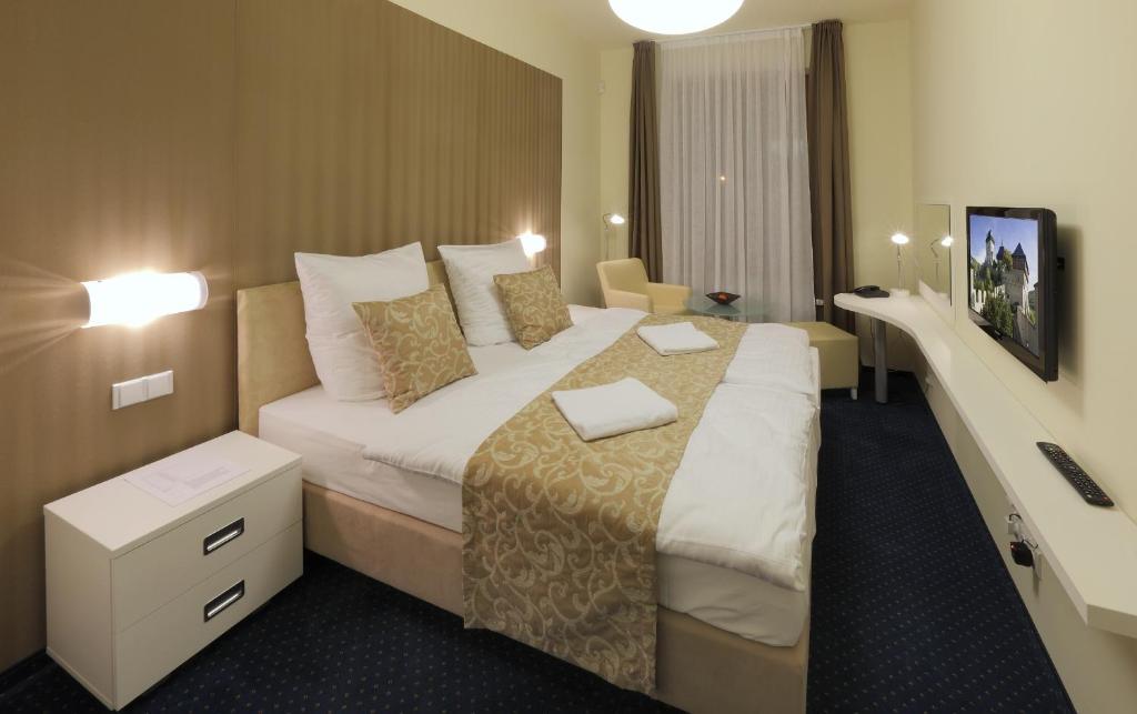 a hotel room with a large bed in a room at Esmarin wellness hotel in Mníšek pod Brdy