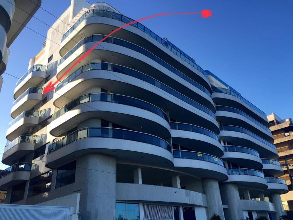 um papagaio vermelho está a voar em frente a um edifício em Residente Lord Cabo Frio em Cabo Frio