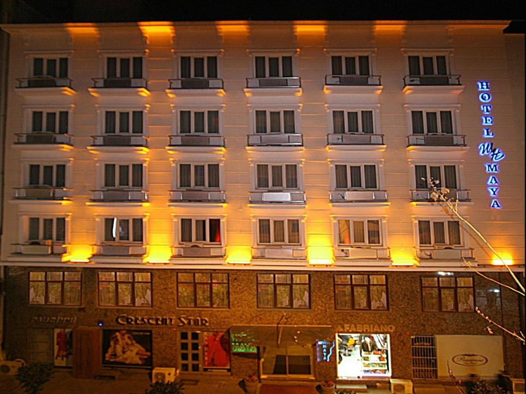 un gran edificio blanco con un cartel. en Maya Hotel, en Estambul