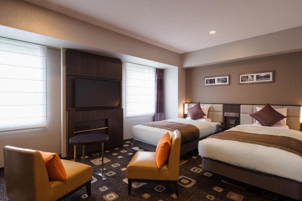 a hotel room with two beds and a flat screen tv at Hotel Mystays Premier Akasaka in Tokyo