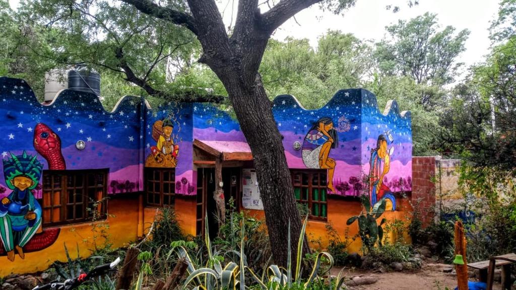 a building with a painting on the side of it at Giramundo Hostel y Posada Eco-Cultural in San Marcos Sierras