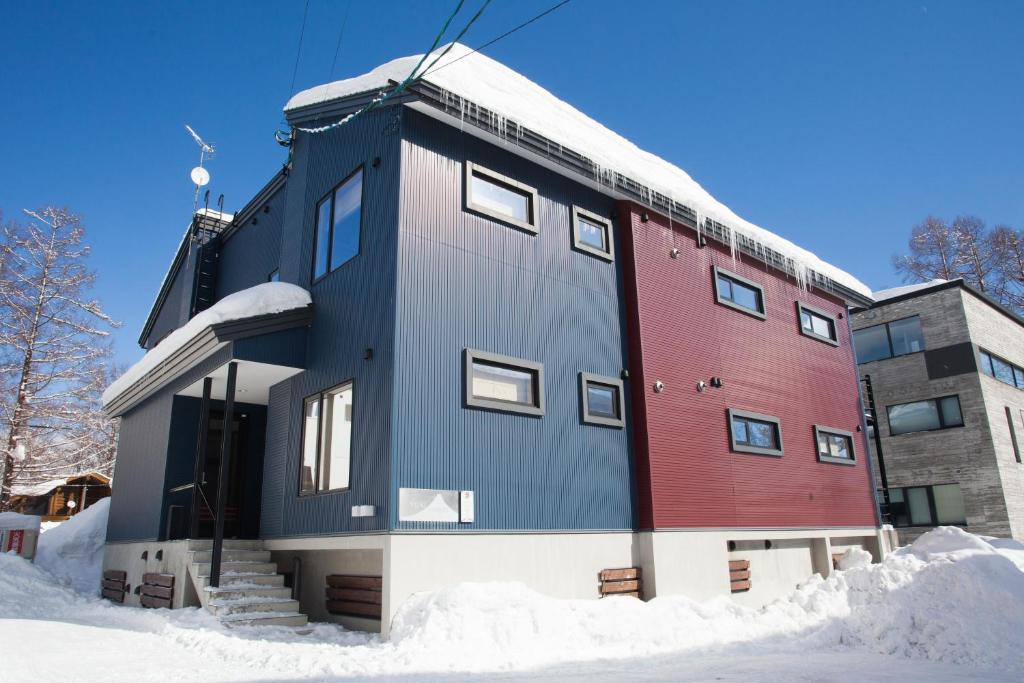 un edificio con la neve sul terreno di fronte ad esso di Yuki Yama Apartments a Niseko