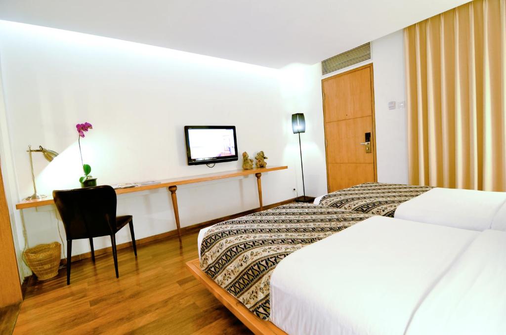 Postel nebo postele na pokoji v ubytování Gumilang Regency Hotel