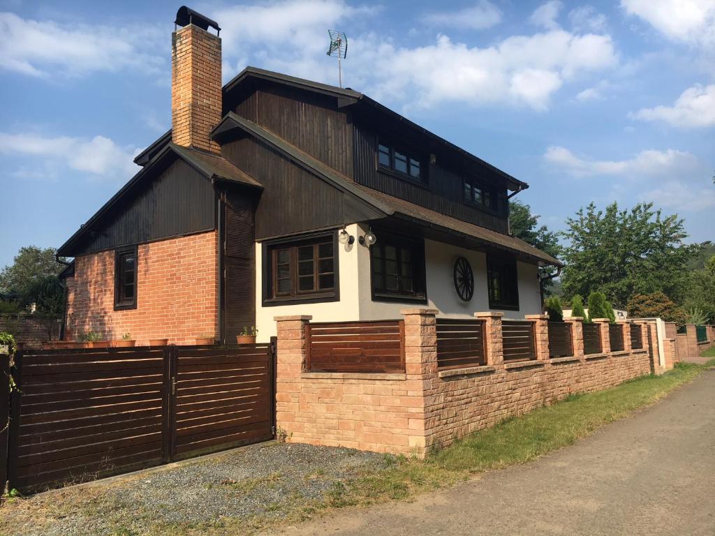 una casa con una pared de ladrillo y una valla en CHATA Privlaky, en Přívlaky