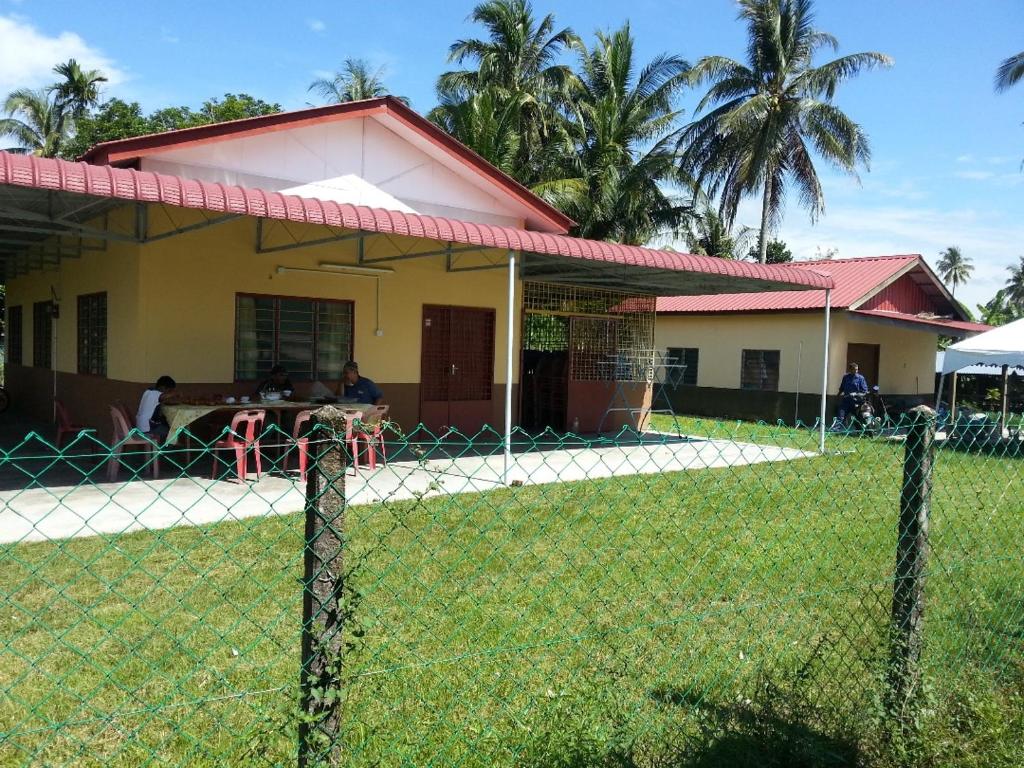 ein Haus mit einem Zaun davor in der Unterkunft Homestay Zulaika Kota Aur in Kepala Batas