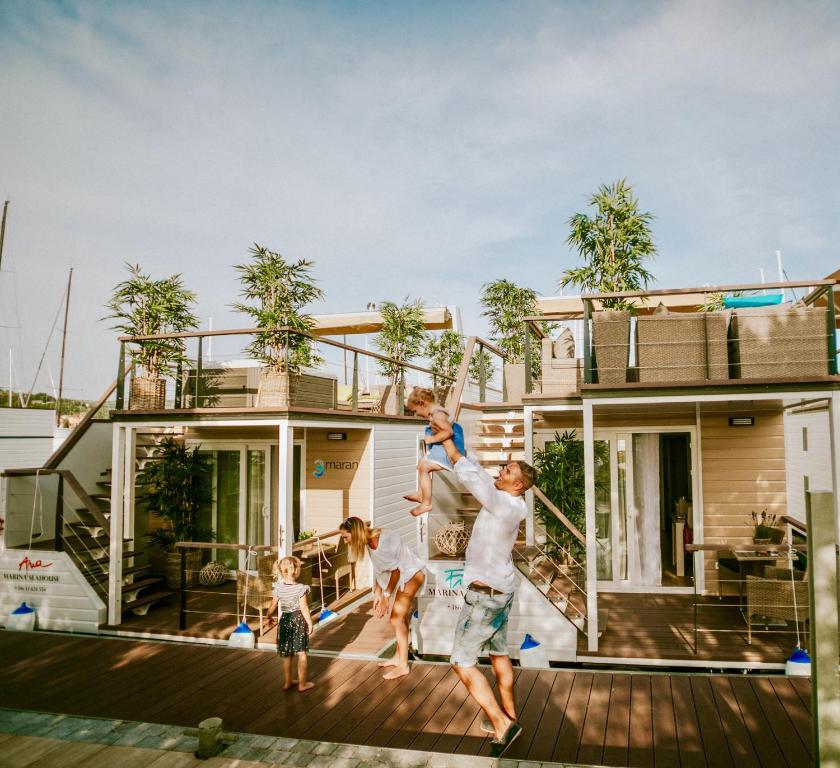 a family jumping in front of a house at Marina seahouse Portorož in Lucija