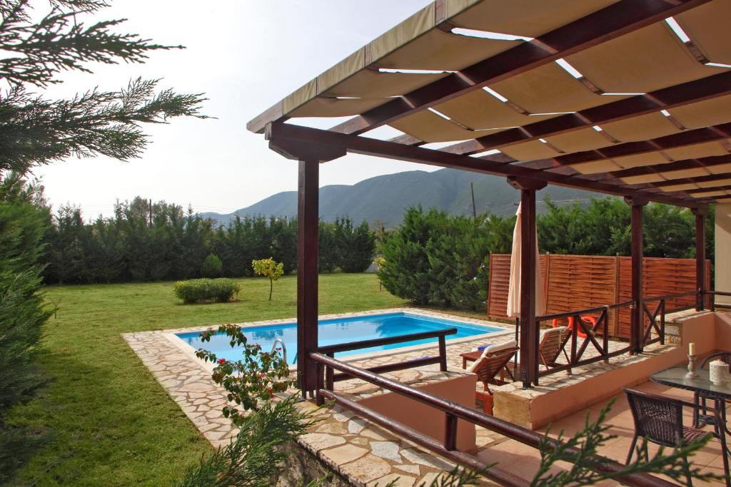 um pátio com uma piscina e uma pérgola em Echinades Resort em Vasiliki