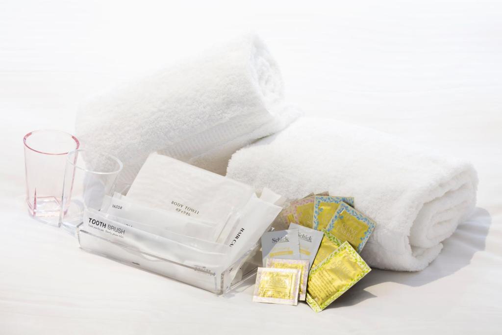 a pile of white towels and a glass at Hotel Mystays Premier Akasaka in Tokyo