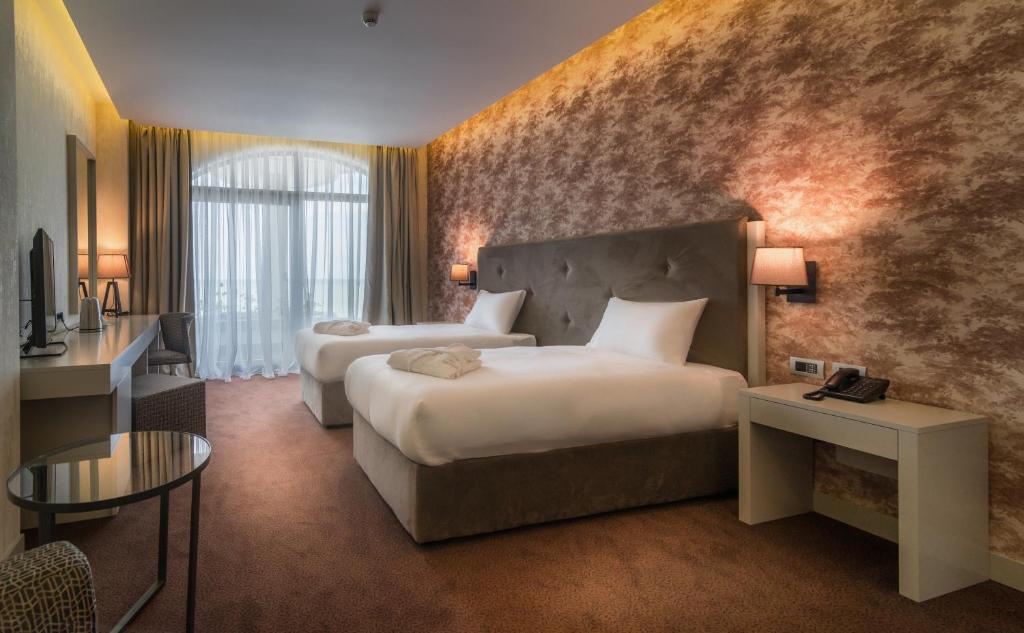 Postel nebo postele na pokoji v ubytování The Grand Gloria Hotel