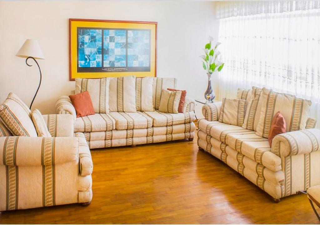 sala de estar con 2 sofás y sofá en San Isidro apartment, en Lima