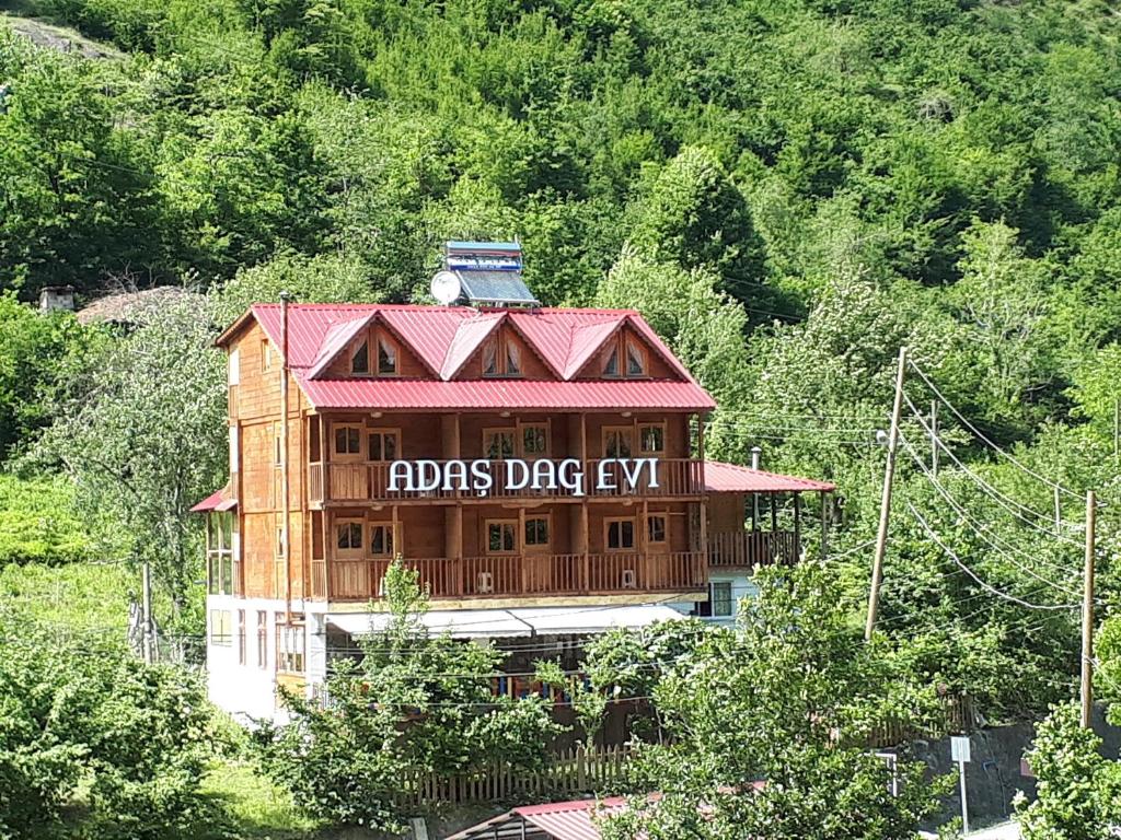 ein großes Holzhaus mit einem Schild drauf in der Unterkunft Adas bungalov Dag Evi in Aralık
