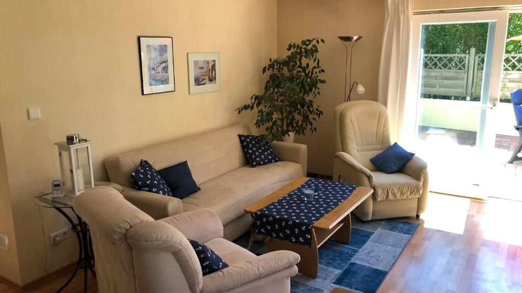sala de estar con sofá, sillas y mesa en Ferienwohnung Moin, en Kiel
