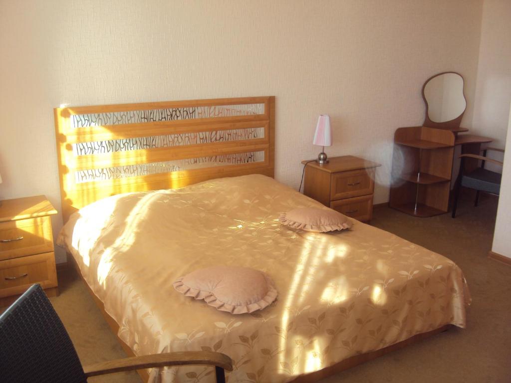 a bedroom with a large bed with a wooden headboard at Sanatoriy Zhosaly in Qarqaraly