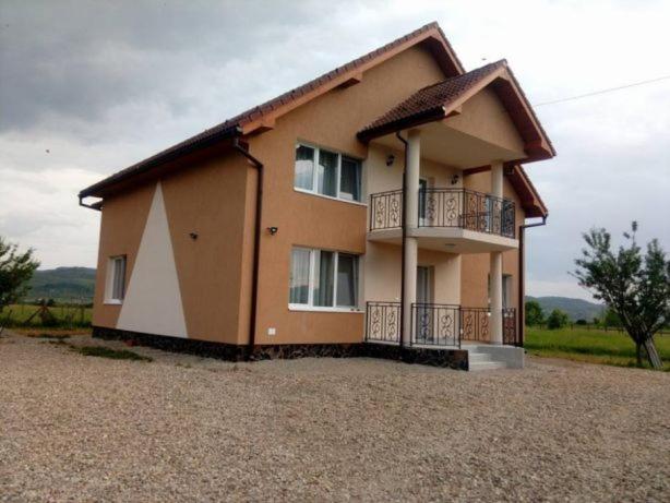 a house with a balcony on the side of it at Vila Lorin in Cristeştii Ciceiului