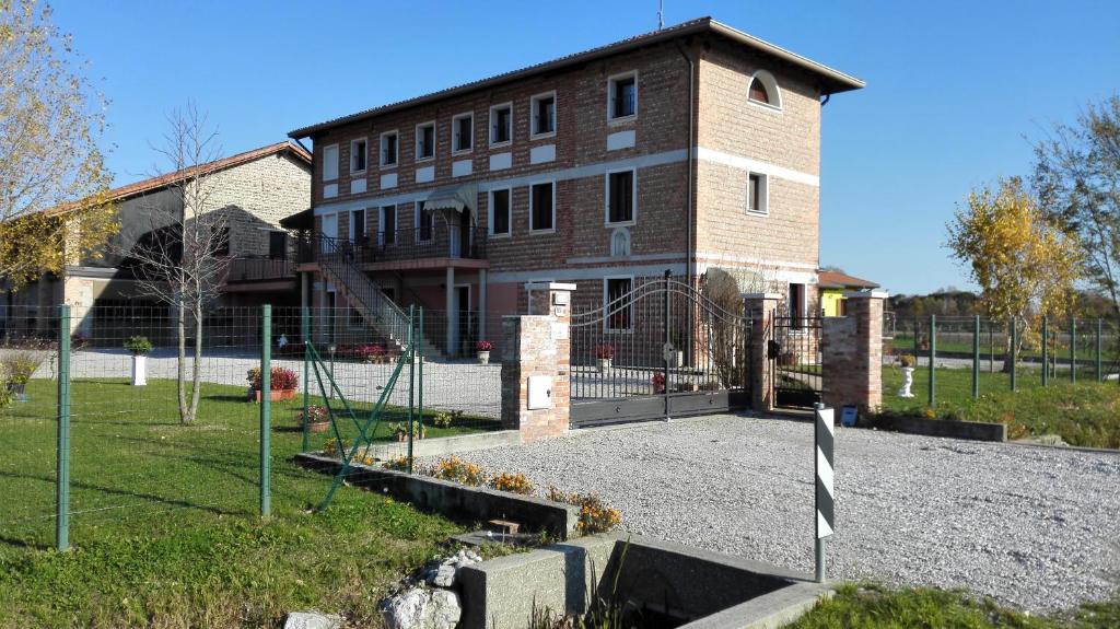 a large brick building with a fence in front of it at Chiaro di Luna in San Vito al Tagliamento