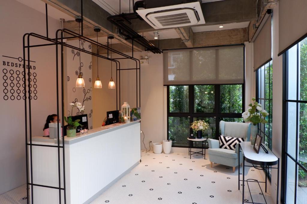 a room with a reception counter and a table and chairs at Bedspread Hostel in Bangkok