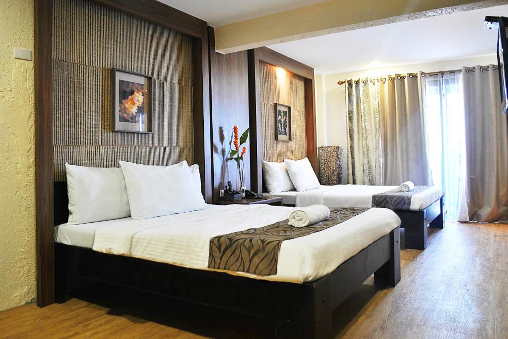 Una habitación de hotel con dos camas y una ventana. en Altamare Dive and Leisure Resort Anilao, en Mabini