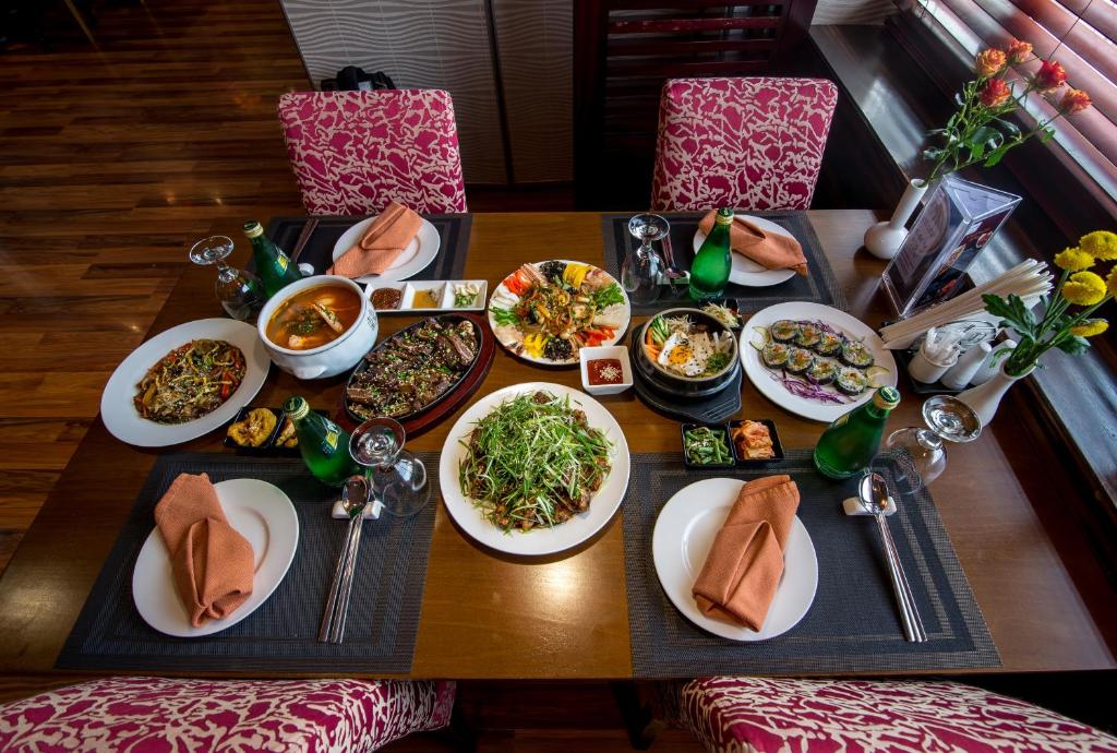 a wooden table with plates of food on it at The Eclipse Boutique Suites in Abu Dhabi