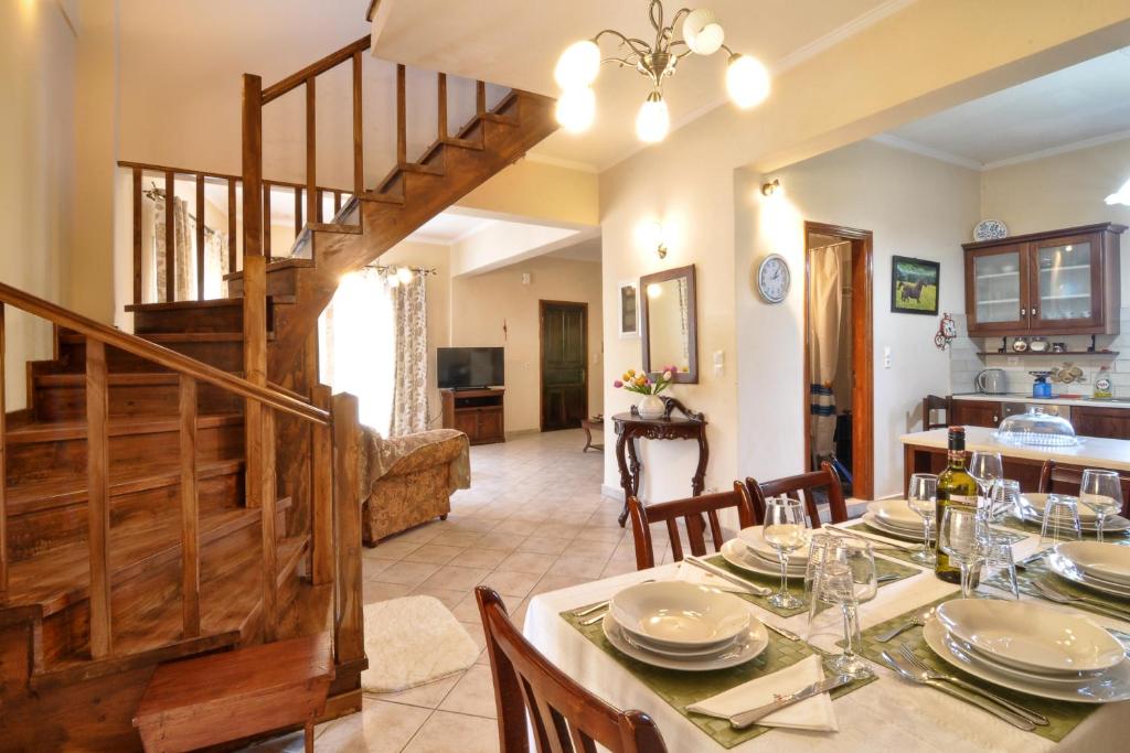 uma sala de jantar com uma mesa e uma escada em Angelica's House em Mantoúkion