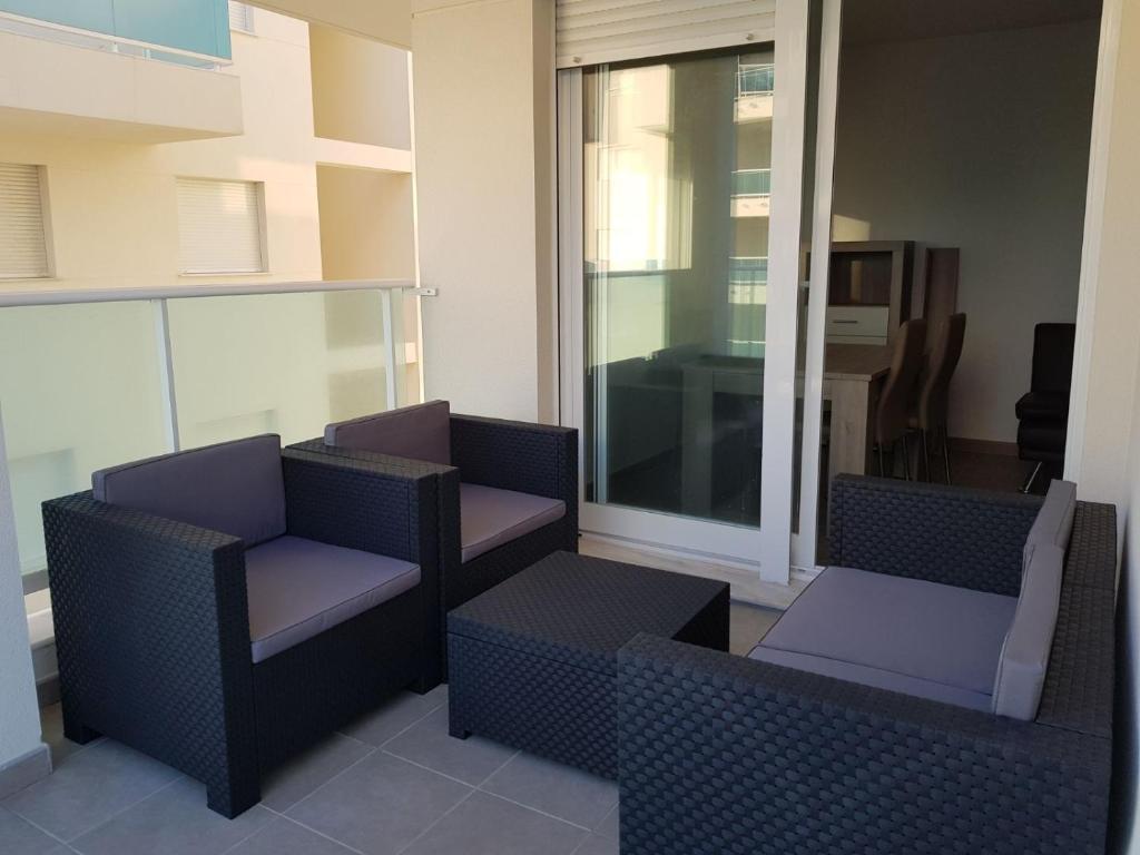 a balcony with two chairs and a window at Apartamento playa Piles in Piles