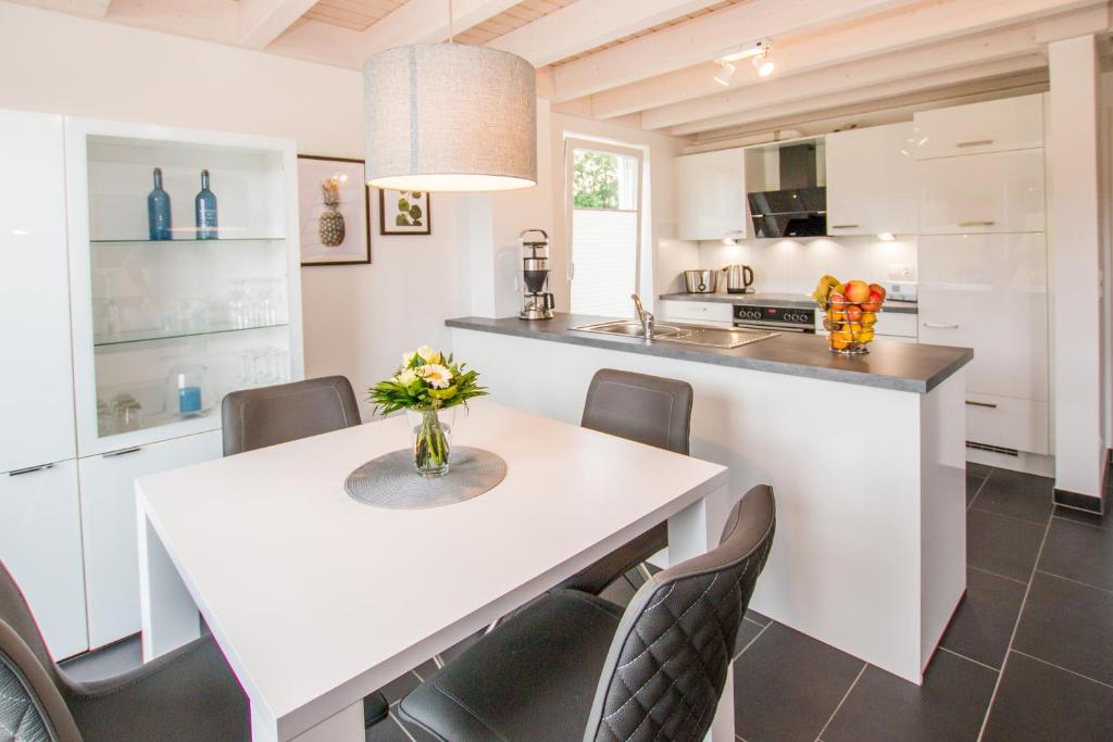 eine Küche mit einem weißen Tisch und Stühlen in der Unterkunft Ferienhaus Hafenkante mit Sky in Nordhorn