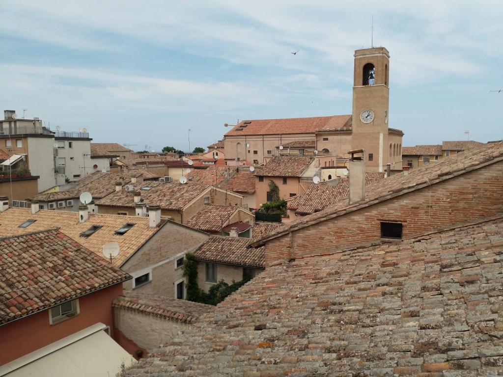 een stad met een klokkentoren op daken bij Da Alma in Fano