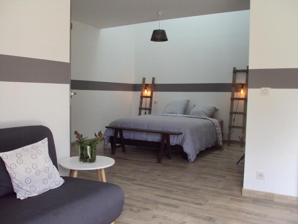 - une chambre avec un lit, un canapé et une table dans l'établissement Tartine & Polochon, à Longué