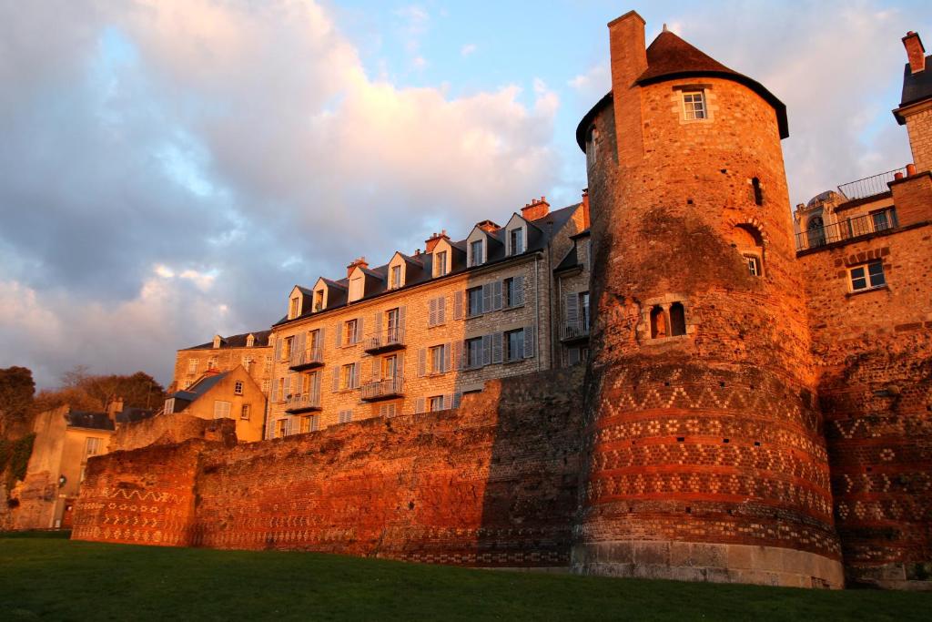 un grand château avec un bâtiment derrière dans l'établissement Logis LouisBlanc, Muraille Romaine, lit Queen-Size, Centre Ville, au Mans