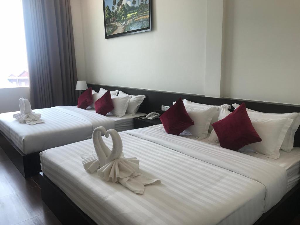 Postel nebo postele na pokoji v ubytování Apple Hotel Two - Near Phnom Penh Airport