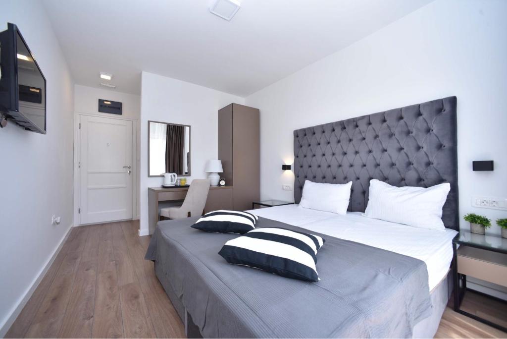 1 dormitorio con 1 cama grande y 2 almohadas en Apartments 110 in Budva, en Budva