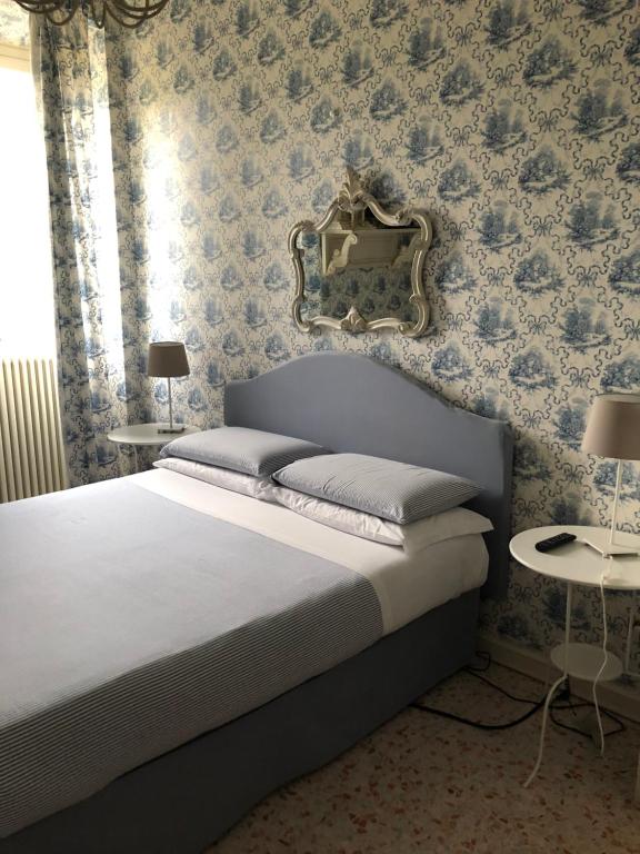 1 dormitorio con 1 cama con espejo en la pared en B&B Country Dreams, en Sulmona