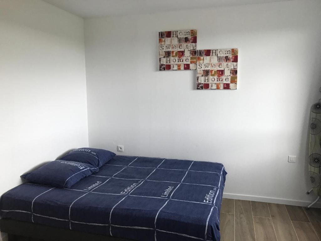 - une chambre avec un lit et une croix sur le mur dans l'établissement Appartement Futuroscope-P', à Chasseneuil-du-Poitou