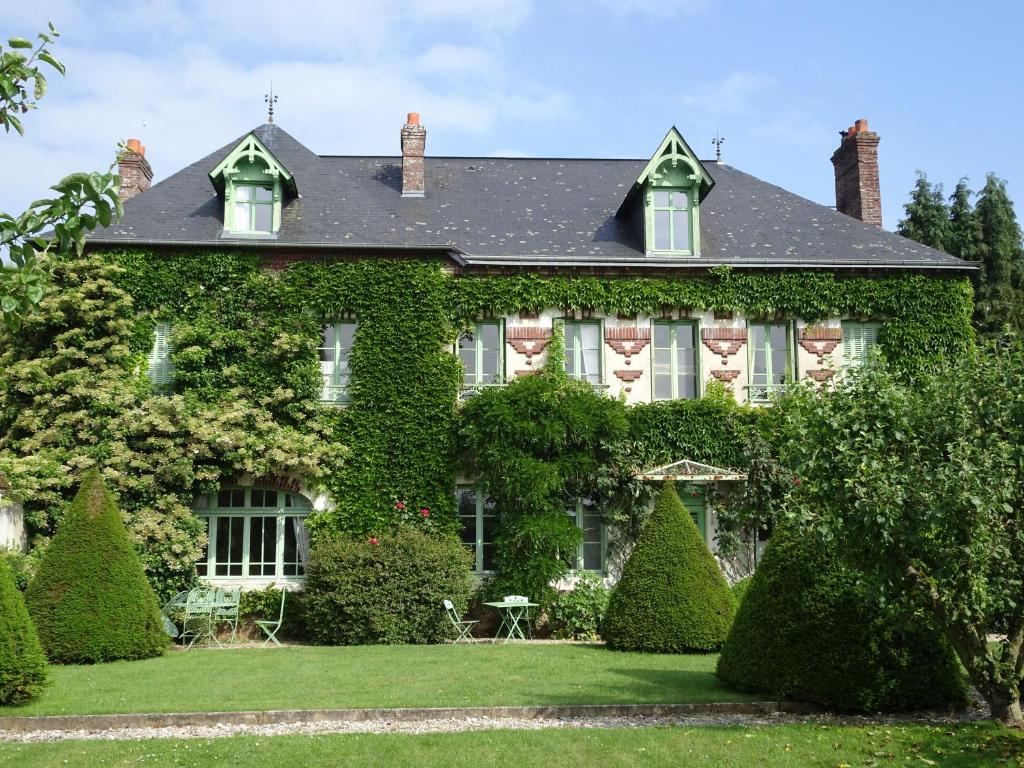 Le Clos des ifs في Thiétreville: منزل مغطى بالحنفية مع الكراسي والأشجار