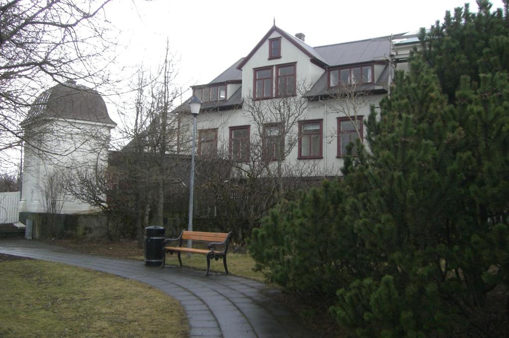 un banco frente a una casa con una torre de agua en Central Guesthouse Reykjavík, en Reikiavik