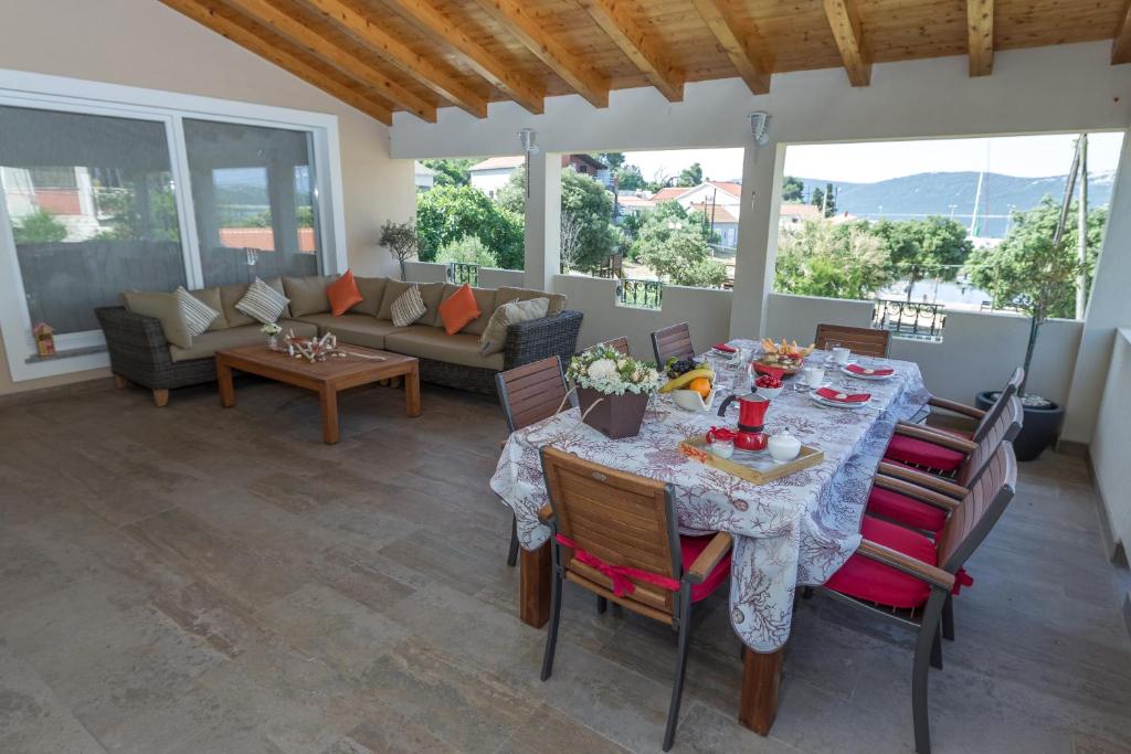 a living room with a table and chairs and a couch at Villa Kaliope in Brgulje