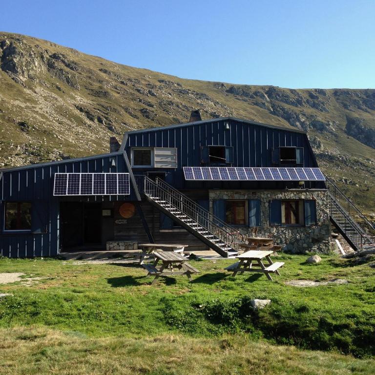 un bâtiment doté de panneaux solaires sur son côté dans l'établissement Refuge des étangs de Bassiès, à Auzat