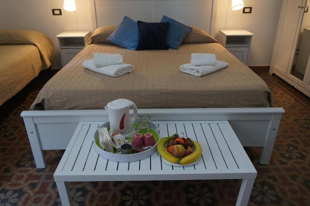 Una cama con una mesa con un bol de fruta. en B&B Casa Laganà, en Reggio Calabria