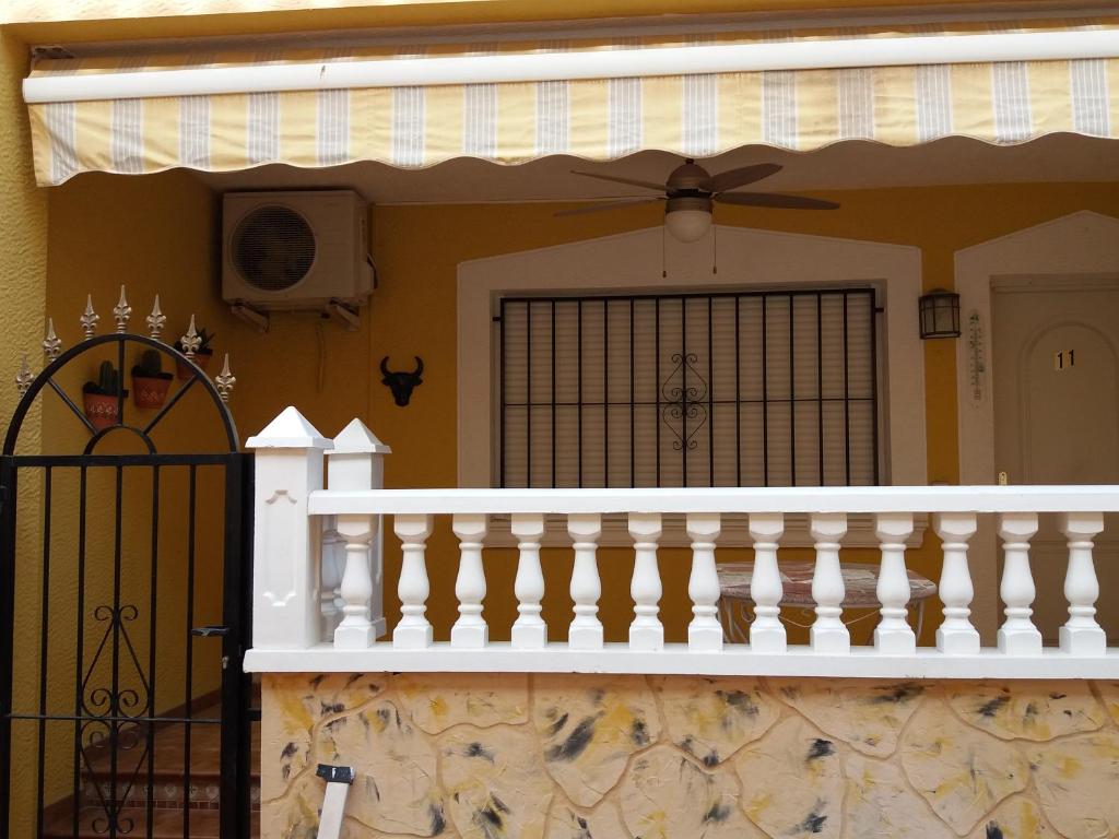 una casa con una barandilla blanca y una puerta en Calle Miguel Delibes, en San Bartolomé