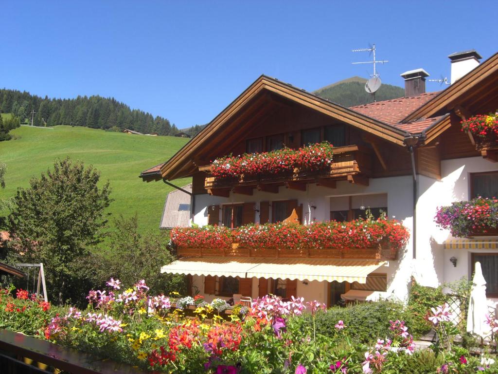 une maison avec des boîtes de fleurs sur son côté dans l'établissement Appartements Johann Bachmann, à San Candido