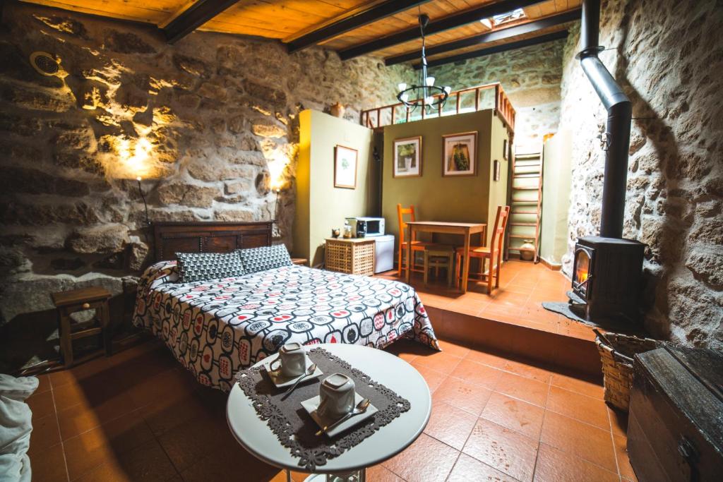 a bedroom with a bed and a wood stove at Caserío da Castiñeira in Sas do Monte