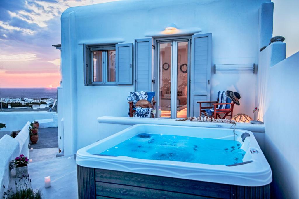 a hot tub in a room with a view of the ocean at Sole Mare Villa in Mýkonos City