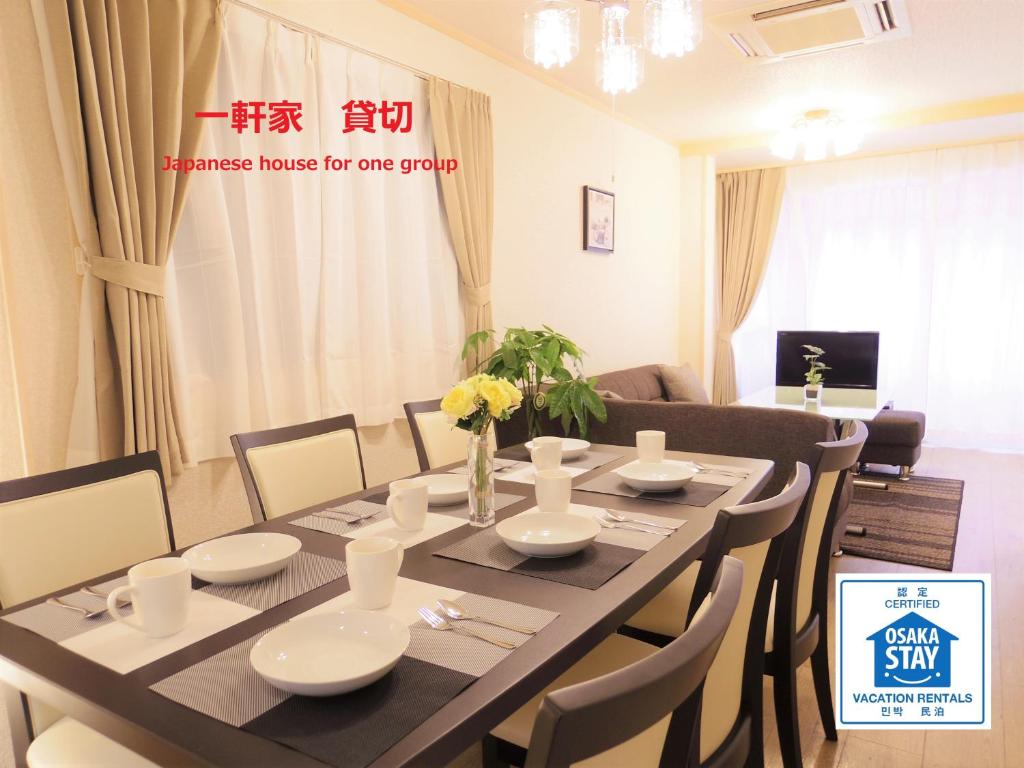 comedor con mesa y sillas en Nao's Guesthouse 2 一軒家貸切, en Osaka