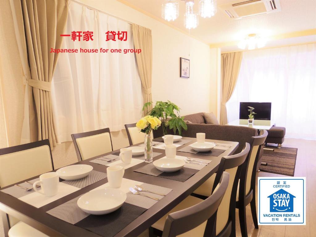 comedor con mesa y sillas en Nao's Guesthouse 2 一軒家貸切 en Osaka