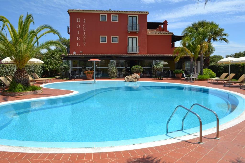 a large swimming pool in front of a building at Hotel Sa Contonera in Àrbatax